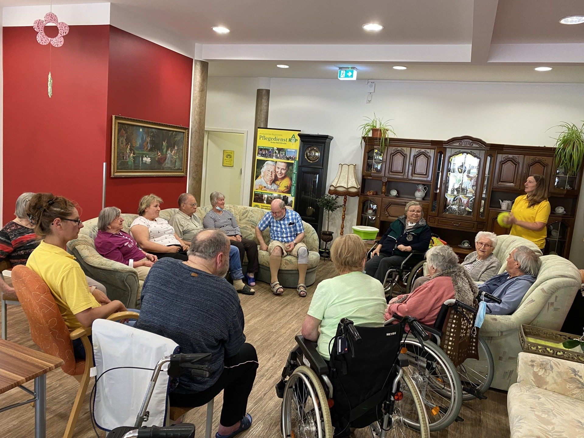 Eine Gruppe von Menschen sitzt im Kreis, möglicherweise in einem Pflegeheim.