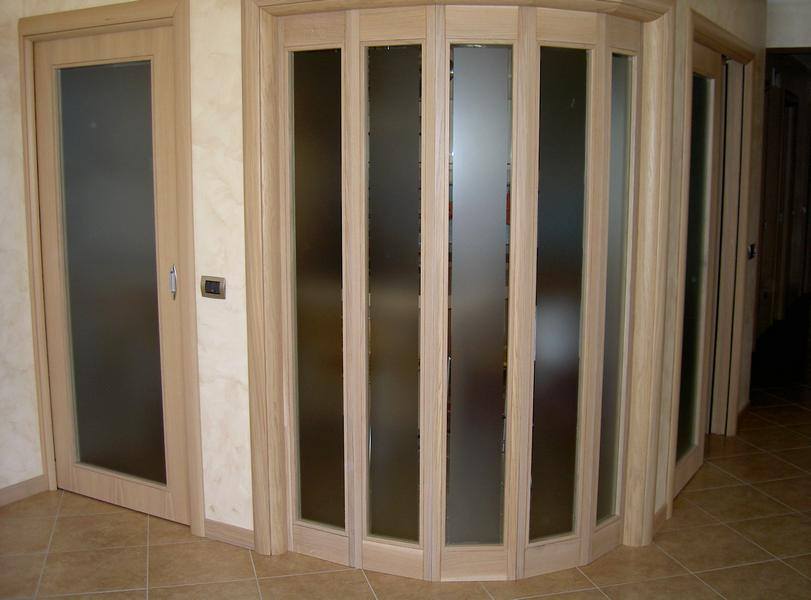 Porta d'ingresso e parete con vetrata in legno