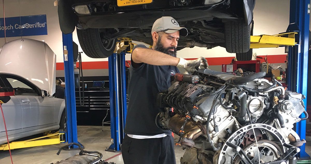 man repairing a machine  | Benz Elite Automotive