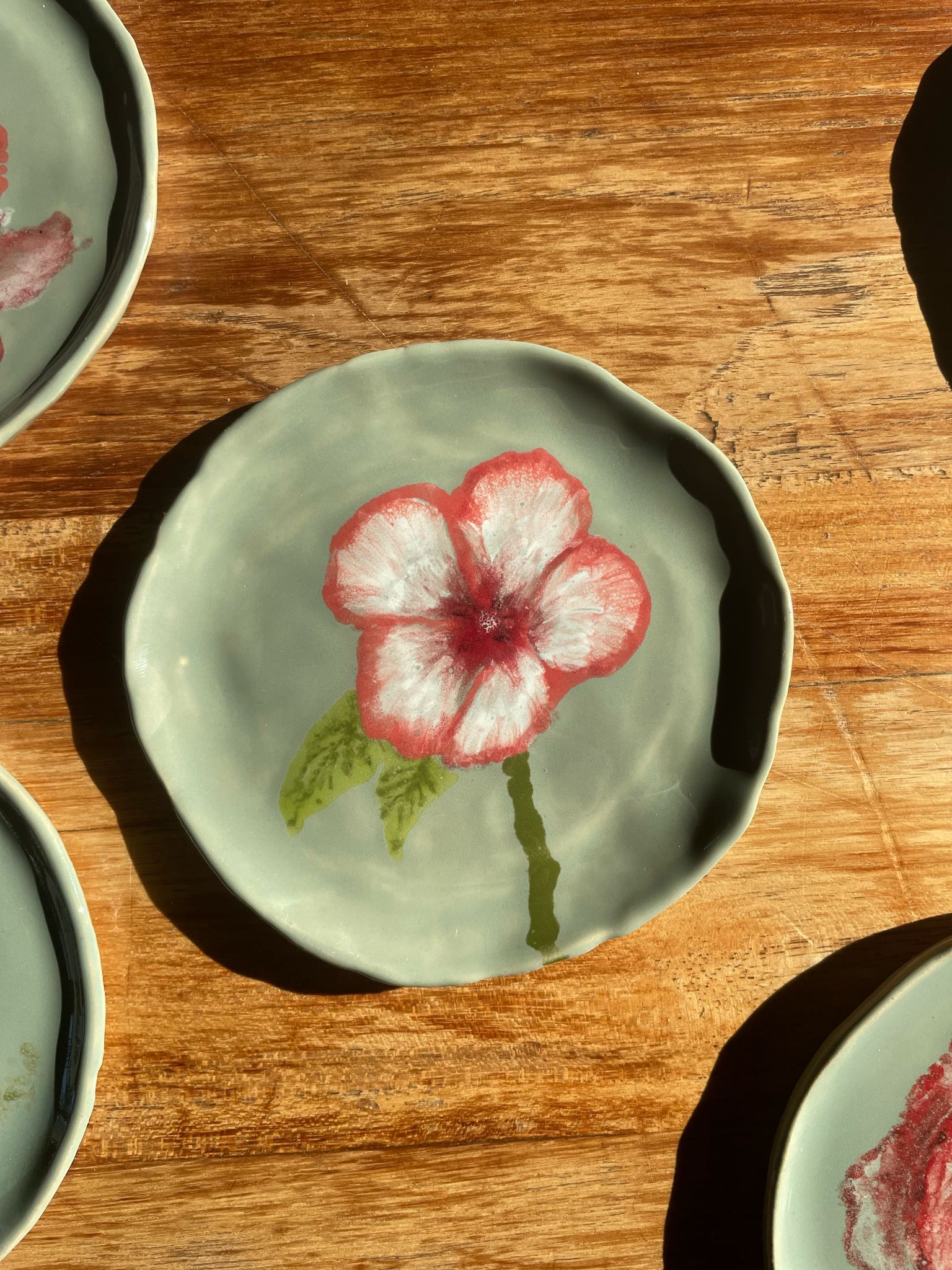 handgemaakt schoteltje van klei met wit en rode bloem
