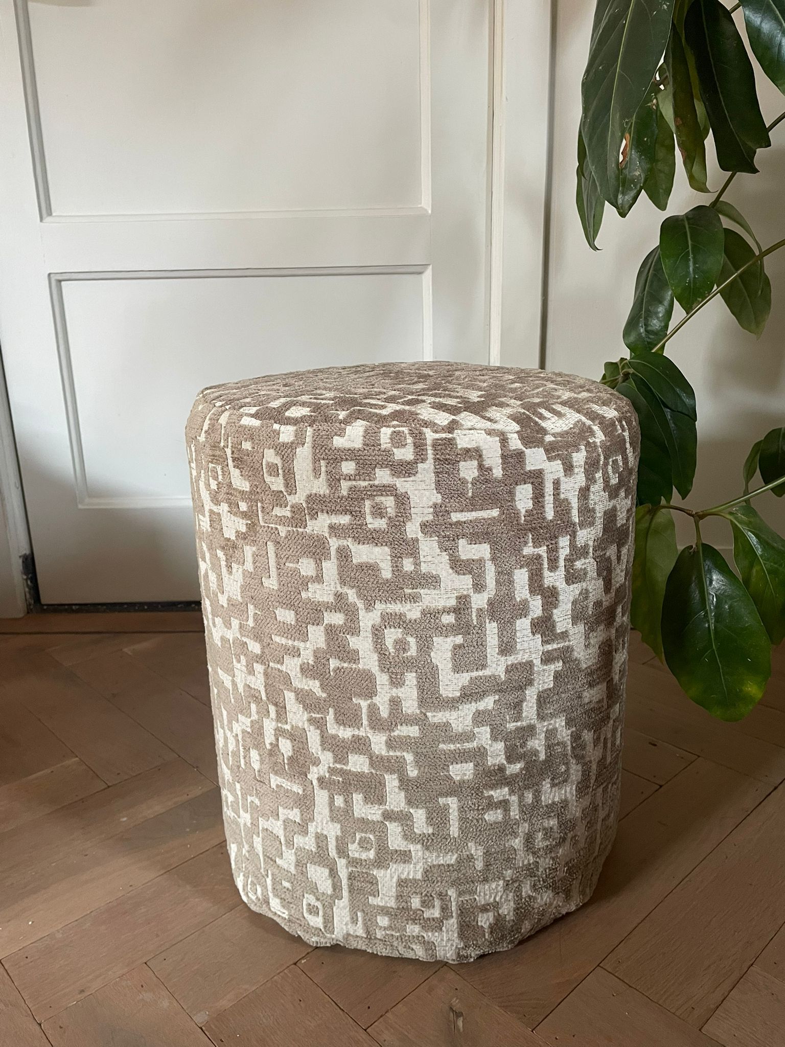 kruk, poef met een textuurrijk, mozaïekachtig patroon van beige en bruine stof