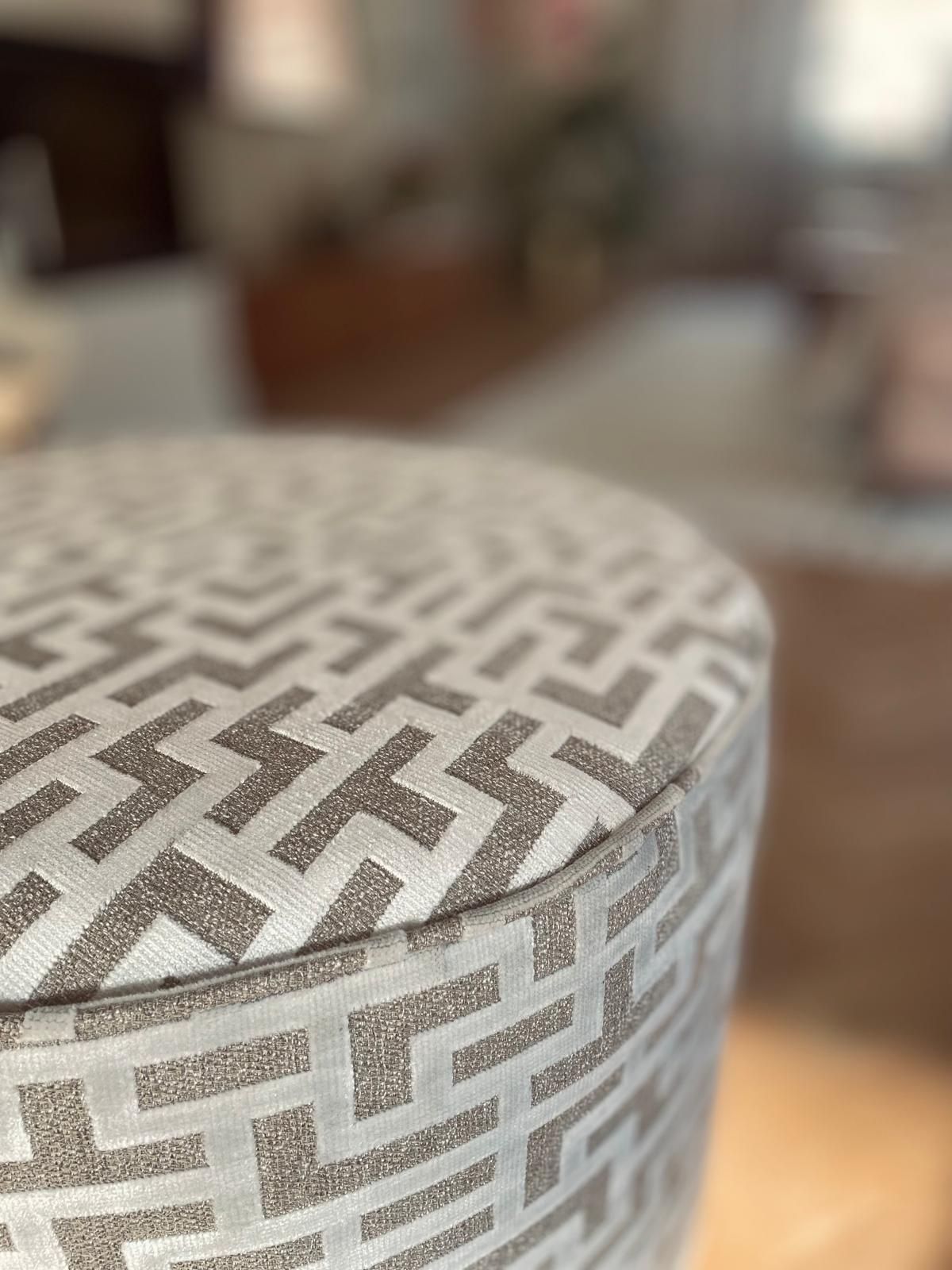 Een ronde poef met een geometrisch patroon, voor een modern interieur