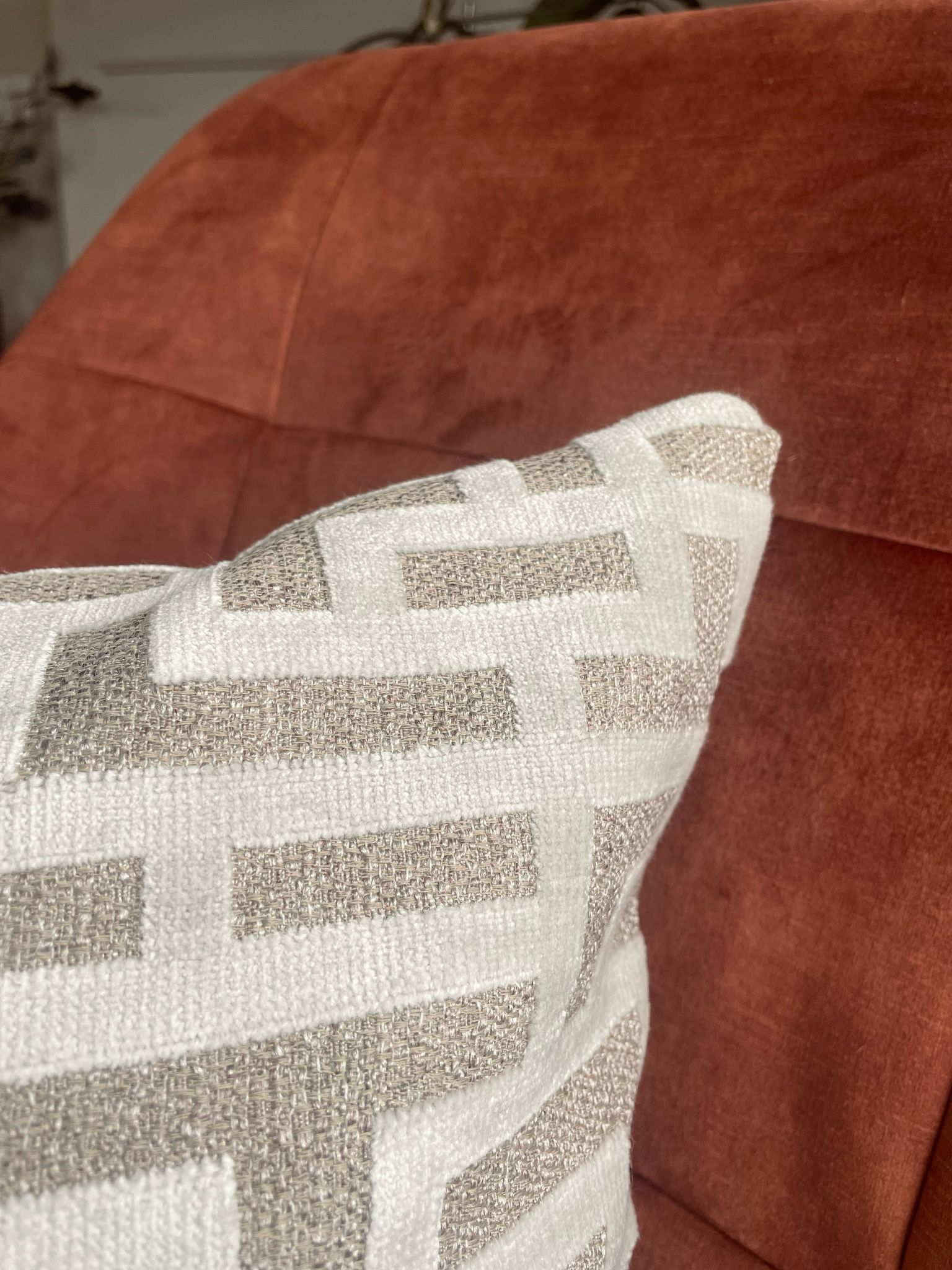 Er ligt een kussen op een bruine bank.