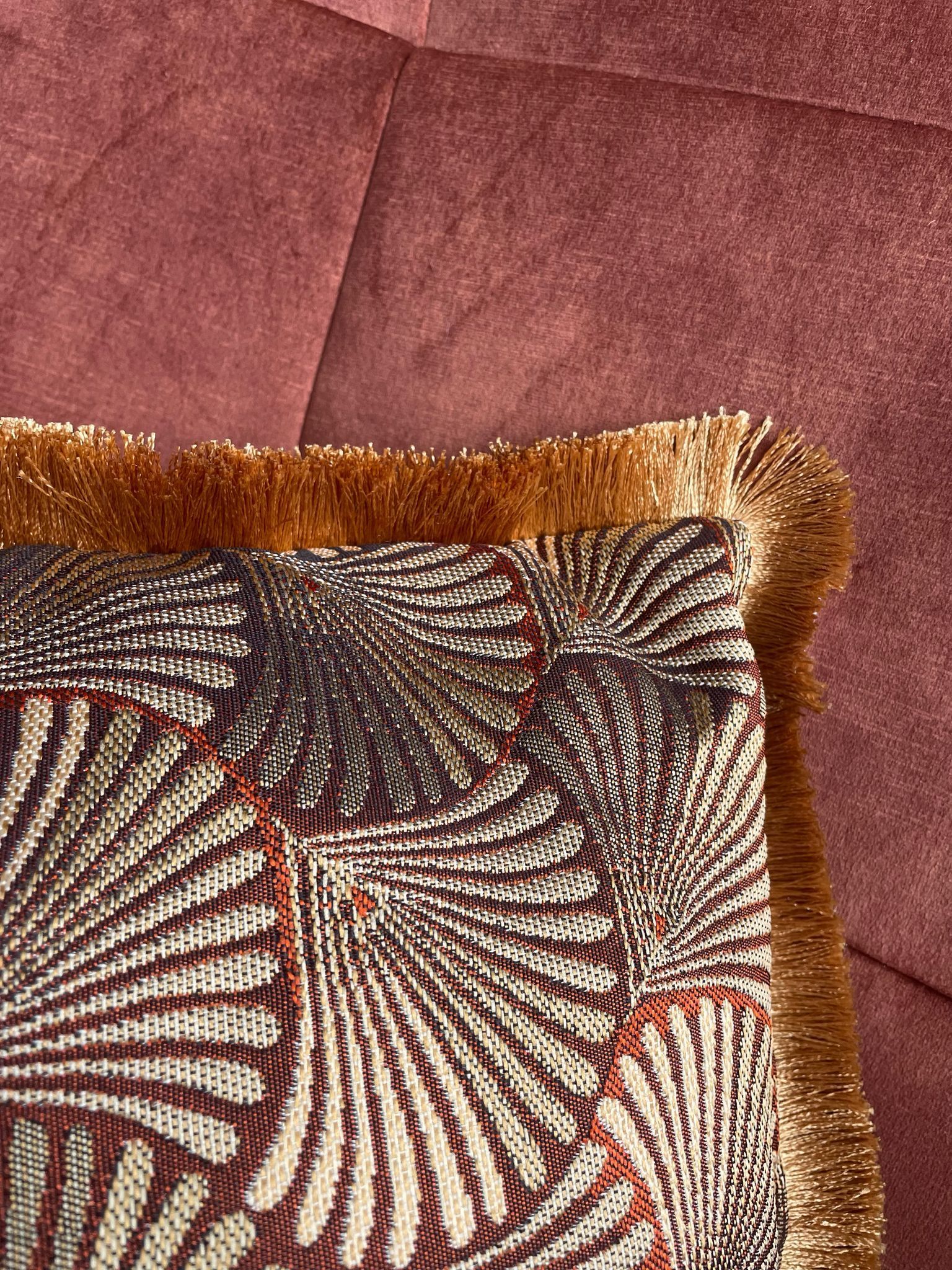 Een handgemaakt kussen met een waaierpatroon en jacquardstof. Met franjes als afwerking voor een stijlvol interieur