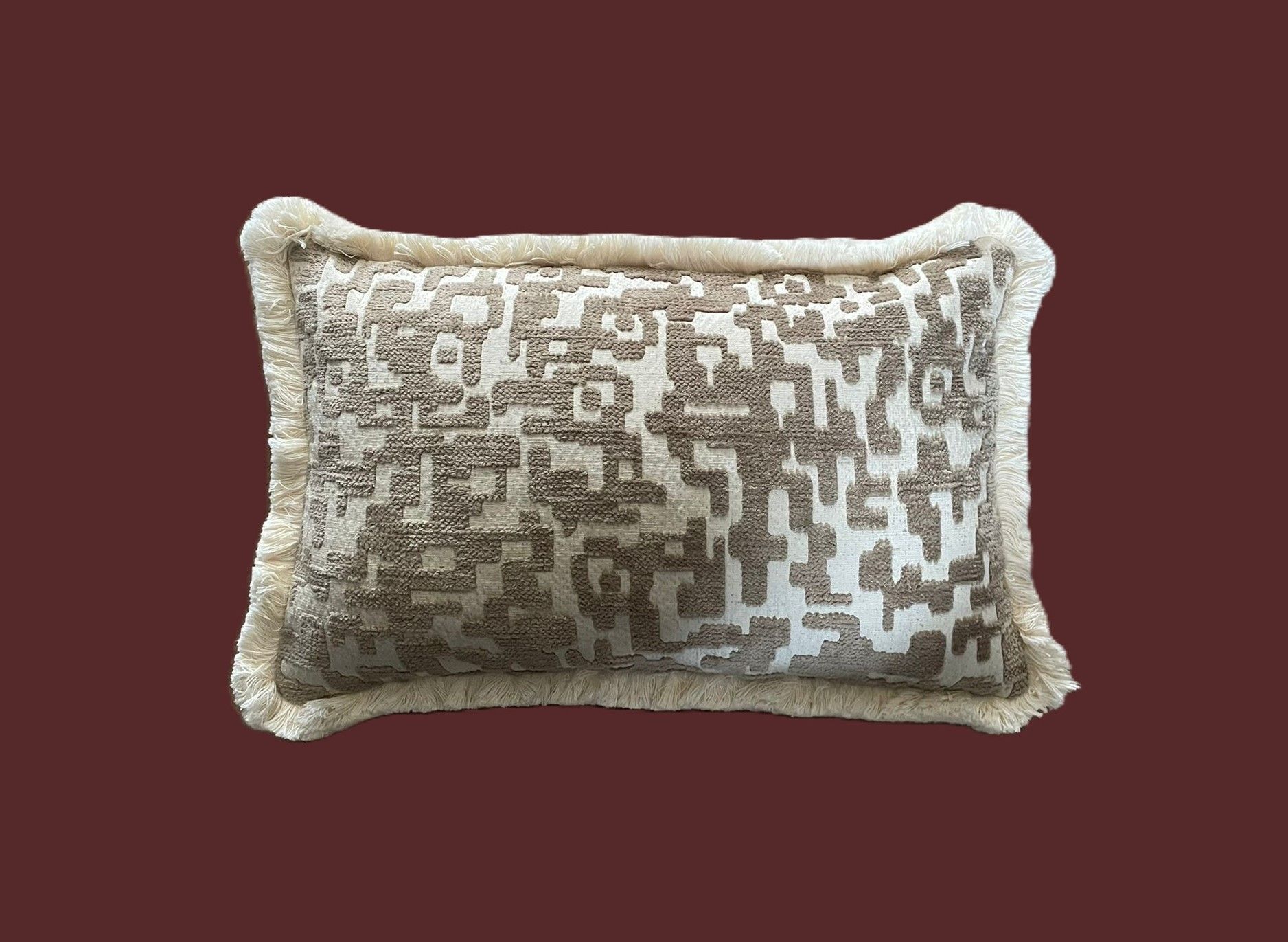 Vierkant kussen met een patroon in beige en crèmekleur, afgewerkt met franjes.