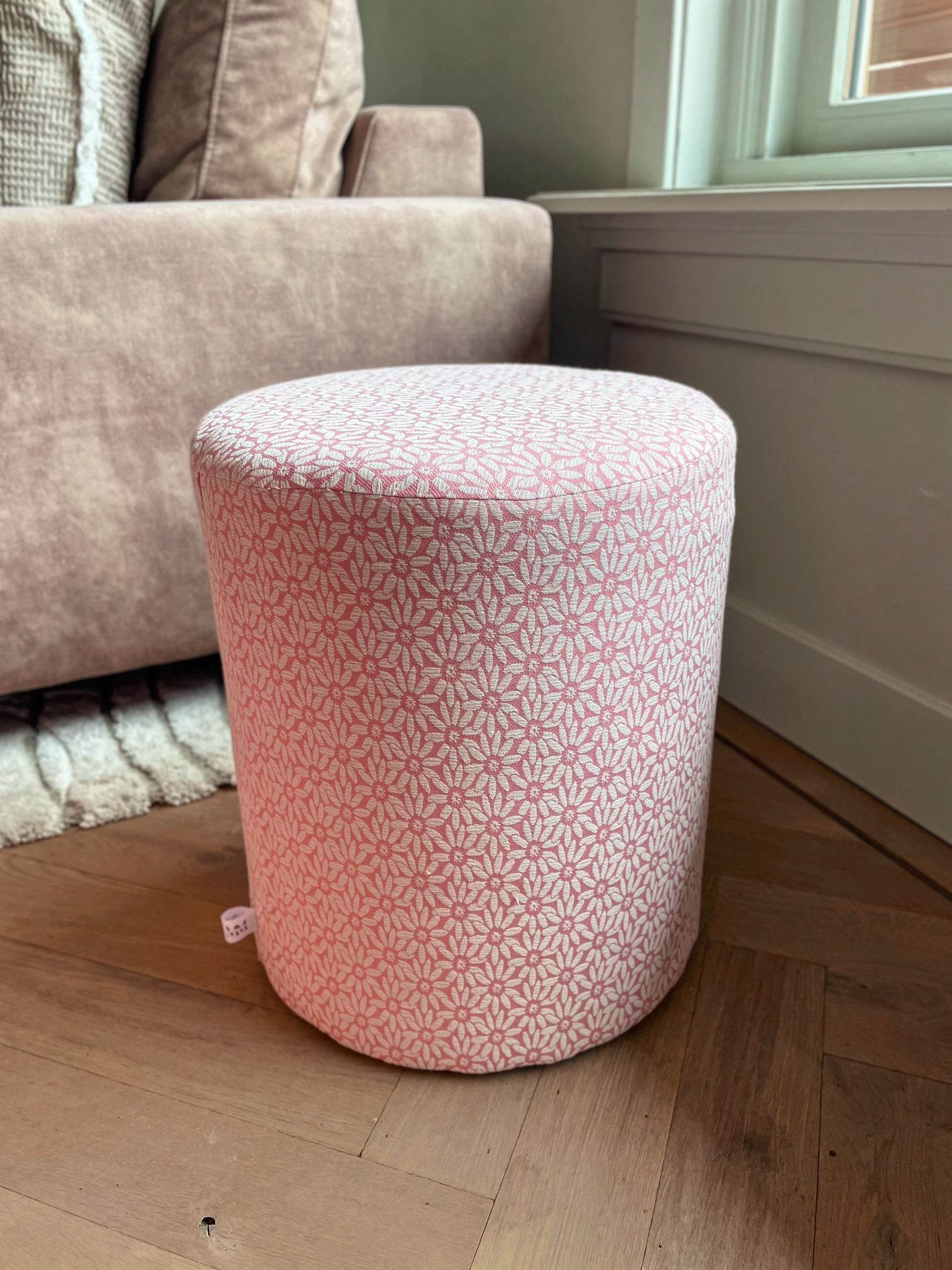 Roze poef met bloemetjes motief, perfect als bijzettafel in de woonkamer