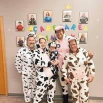 A group of people dressed in cow pajamas are posing for a picture.