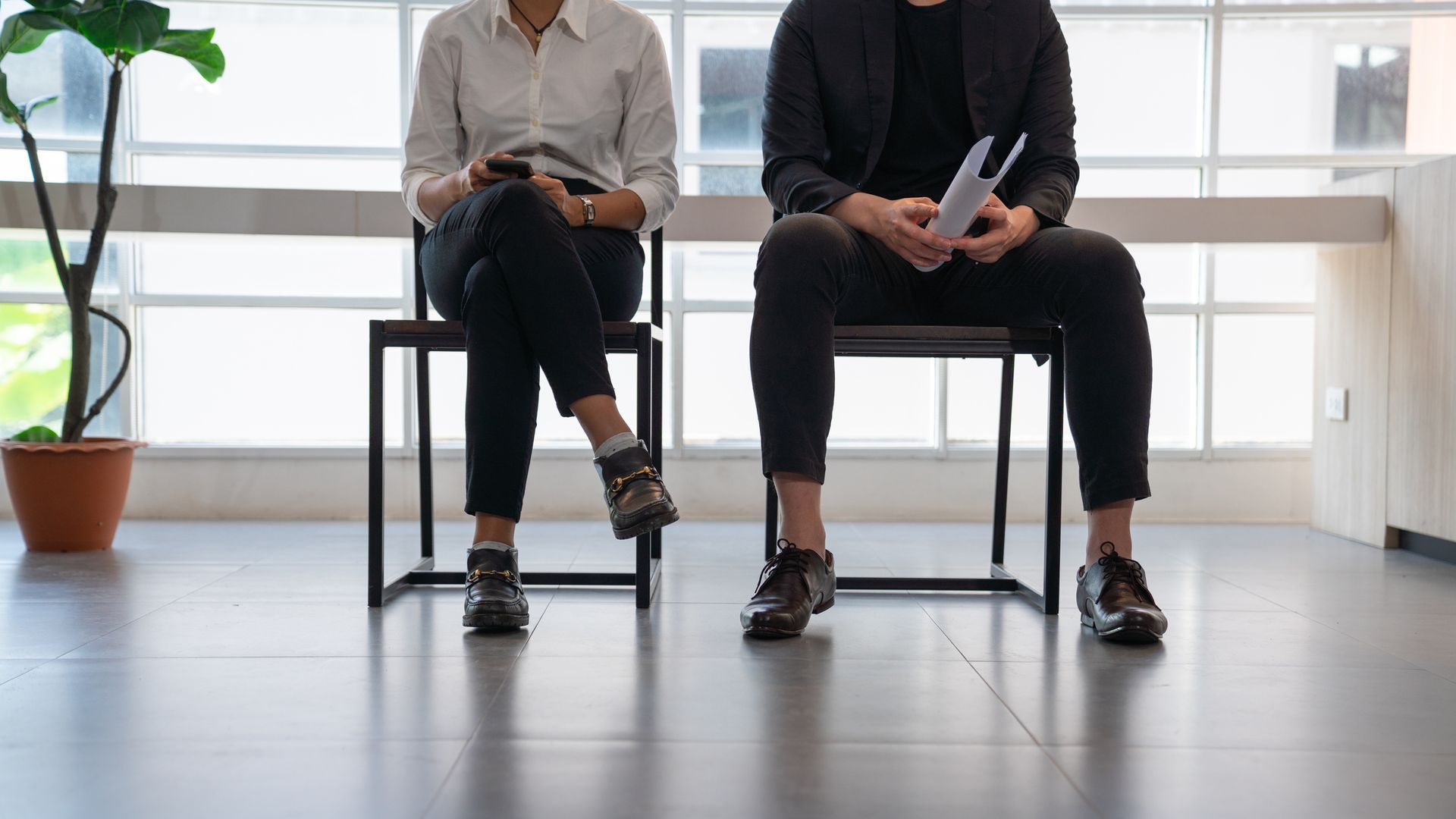 A Man and a Woman Are Sitting in Chairs Waiting for a Job Interview