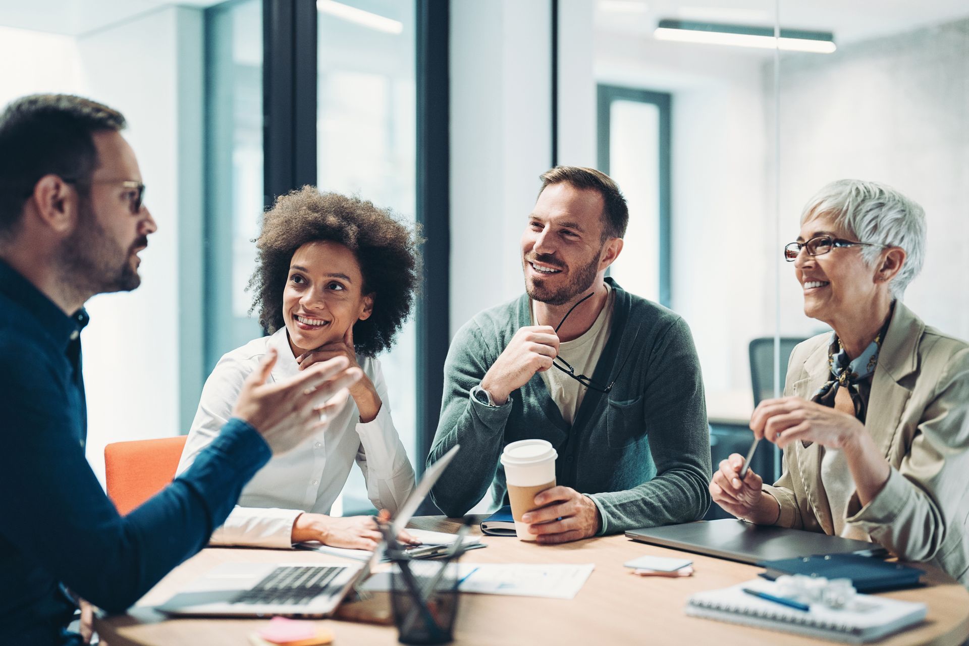 A Group of People Are Sitting Around a Table Having a Meeting