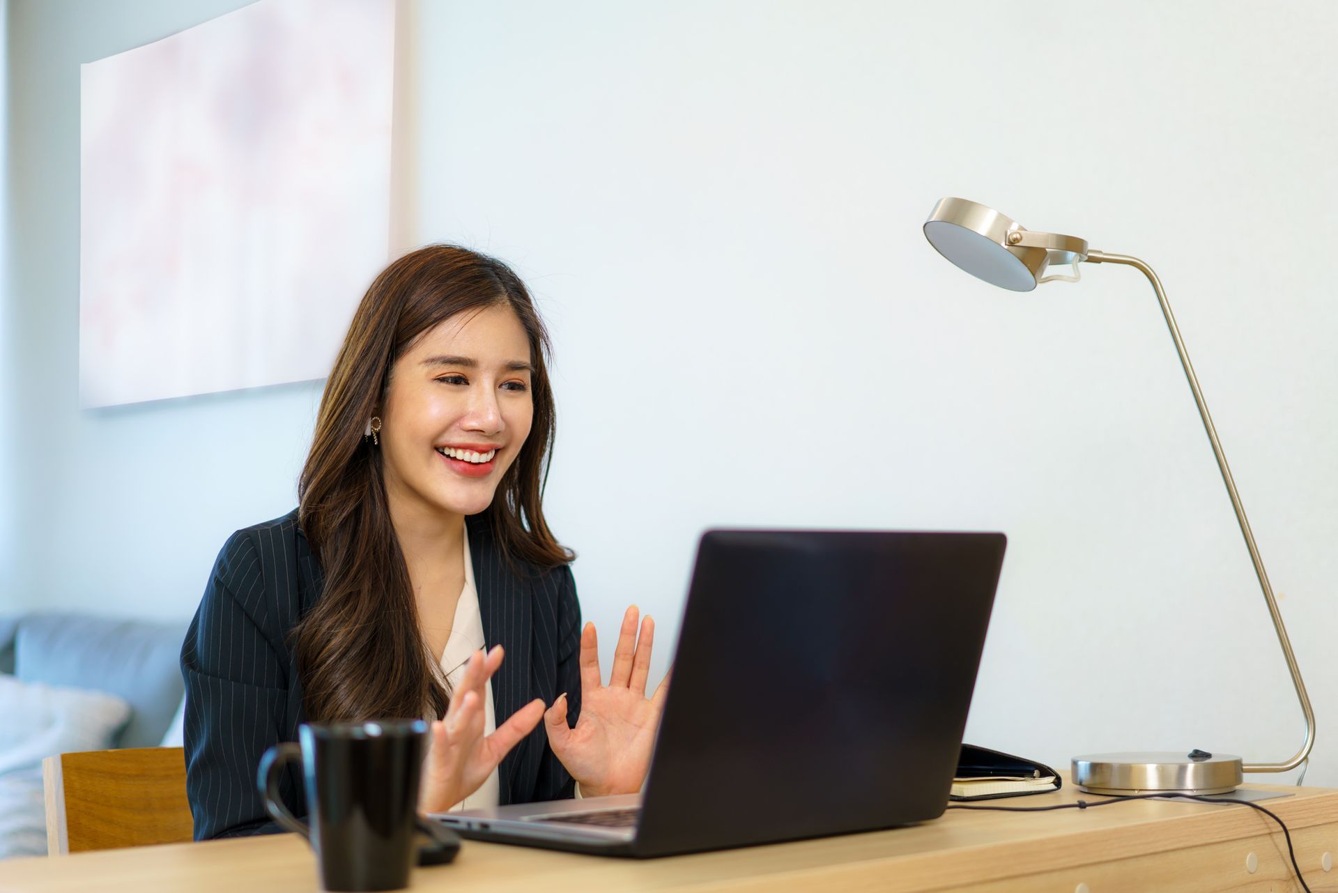 A Woman is Sitting at a Desk Using a Laptop Computer