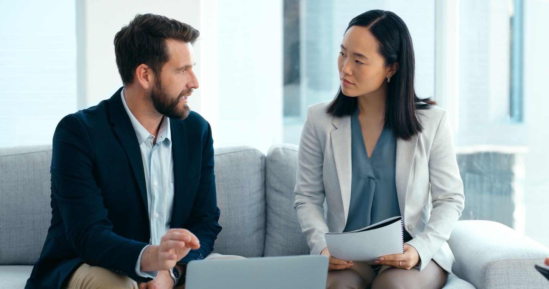 A Man and a Woman Are Sitting on a Couch Looking at a Laptop