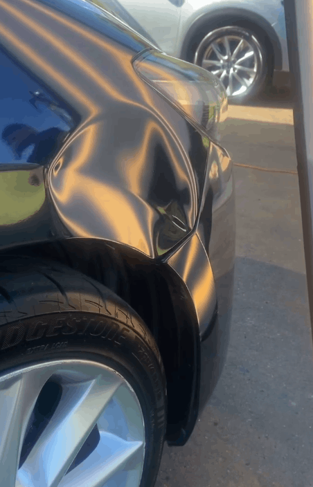 A close up of a car with a damaged fender