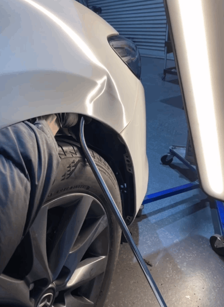 A close up of a car with a damaged fender