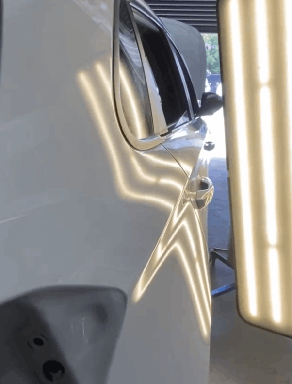 A close up of a car door with a dent in it