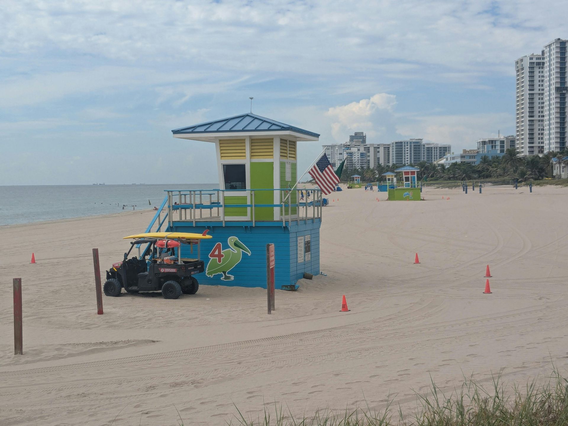Lifeguard tower and ATV in Pompano Beach with orange cones, ocean and high-rises in the background