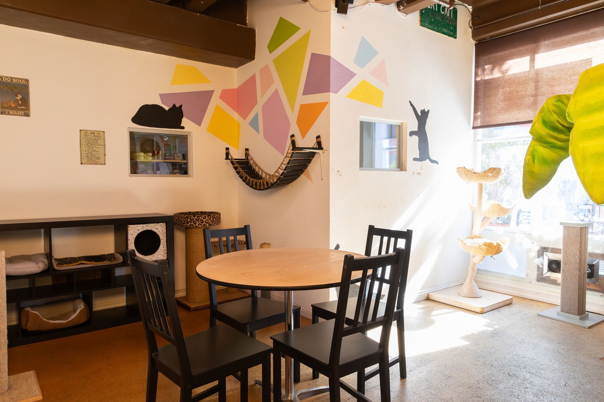 A room with a table and chairs and a painting on the wall.