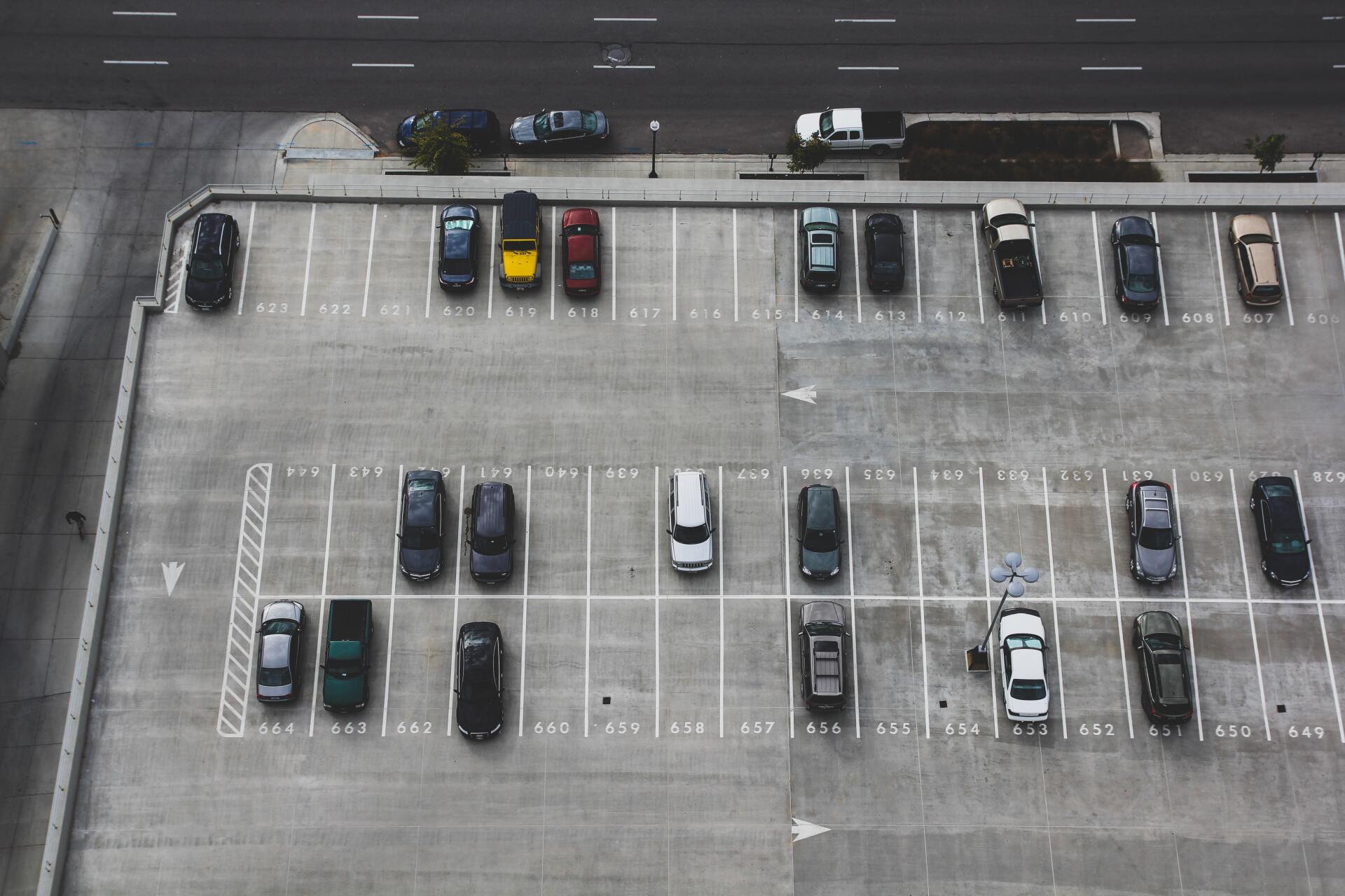 An aerial view of a parking lot filled with cars.