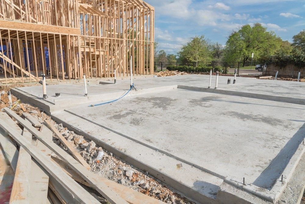 A house is being built with a concrete foundation and a wooden frame.