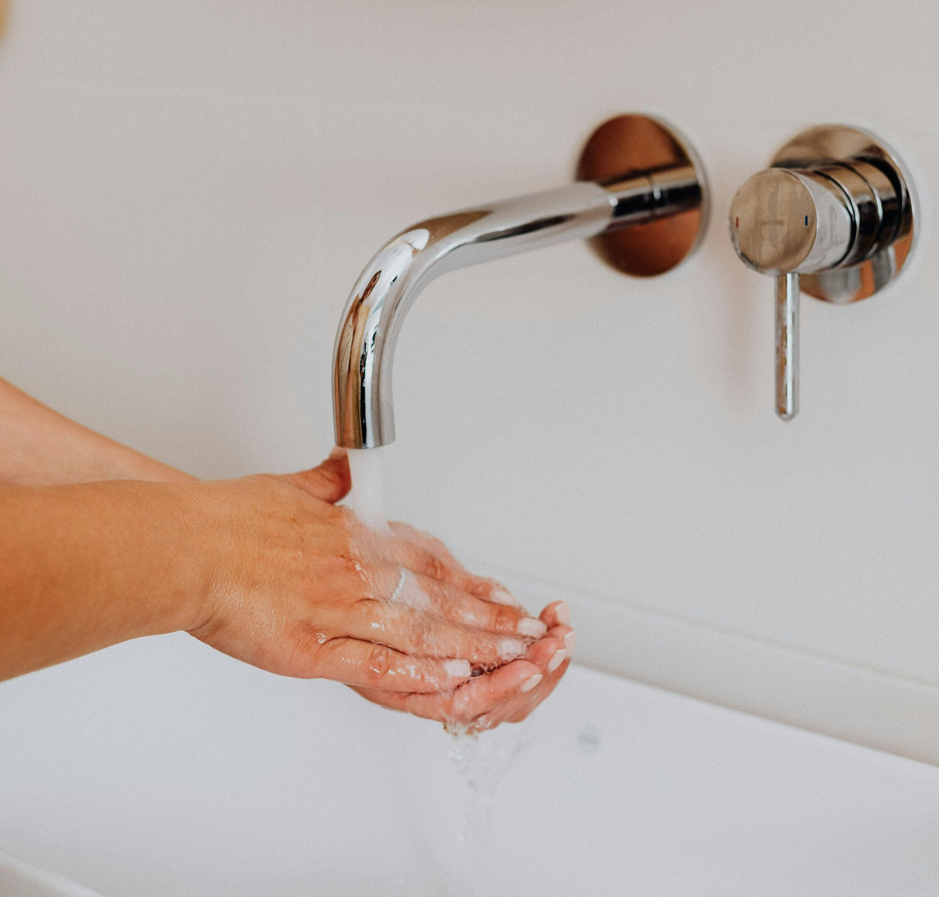 A bathroom with two sinks , a tub , and a large mirror.