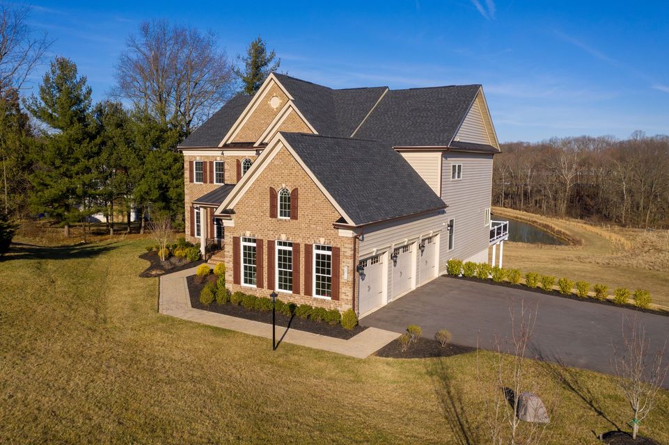 An aerial view of a large brick house with a garage and a driveway.