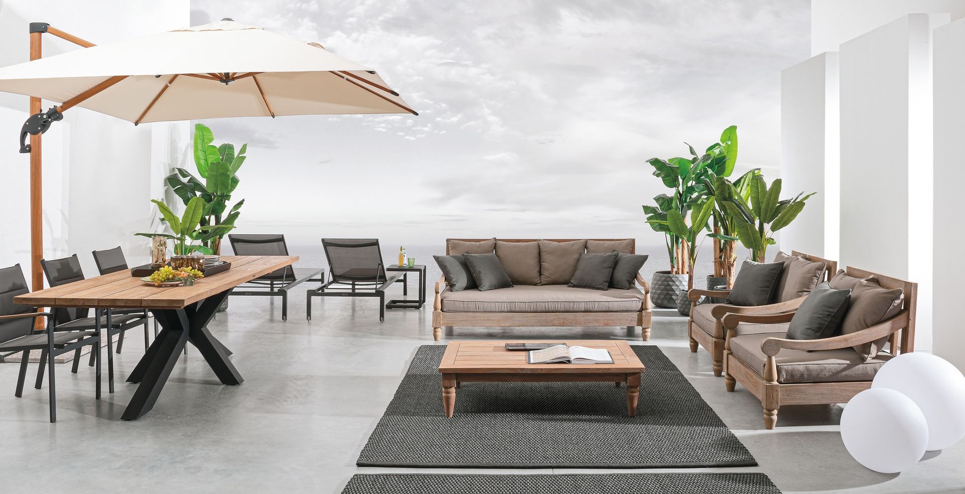 Un soggiorno con divano, sedie, tavolo e ombrellone.