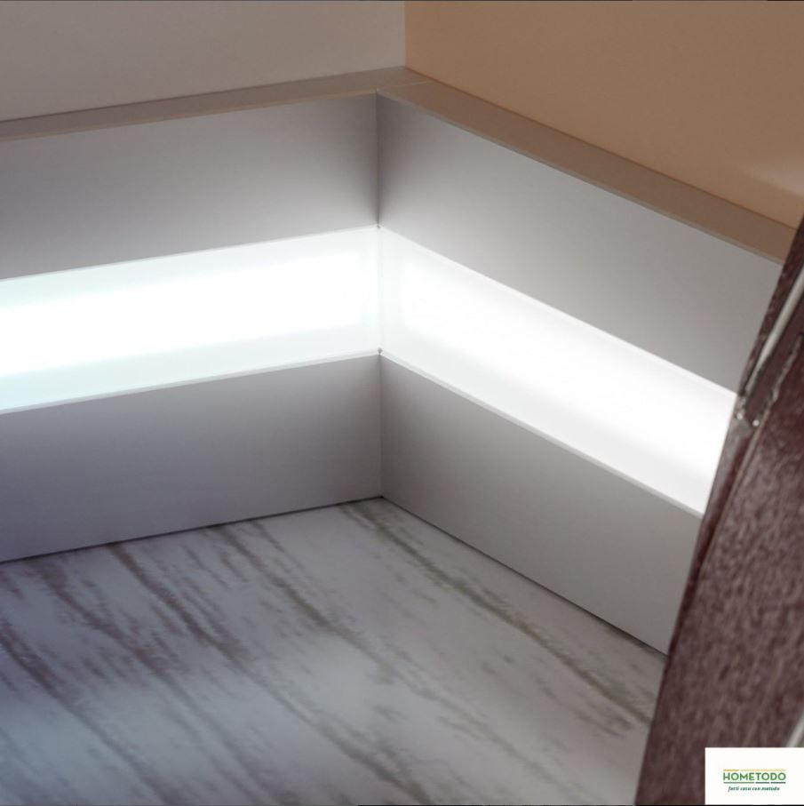 Un angolo di una stanza con una luce sul pavimento