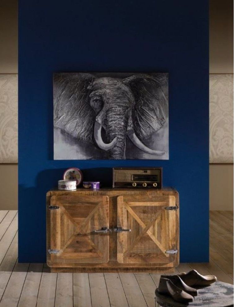 Un dipinto di un elefante è appeso alla parete sopra un mobile di legno.