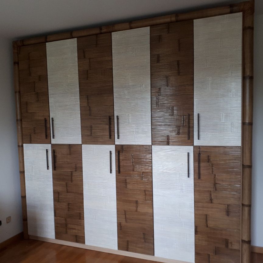 Un grande armadio di legno con ante bianche in una stanza