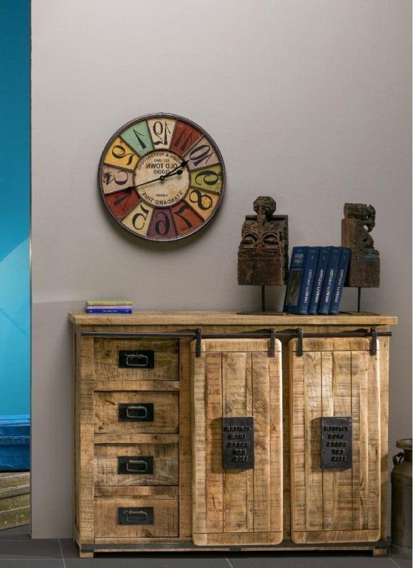 Un orologio è appeso alla parete sopra un mobiletto di legno.