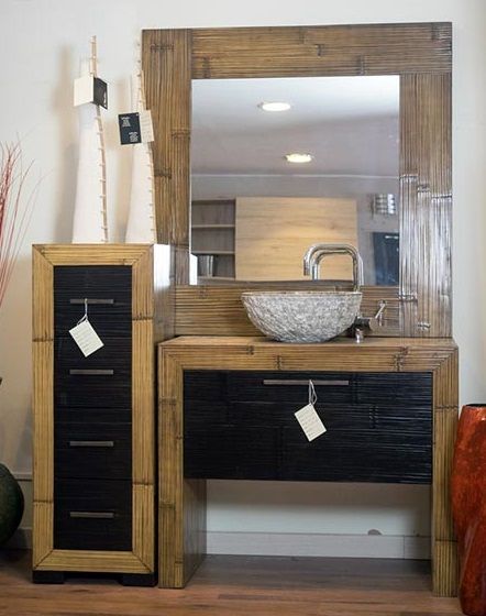 Un bagno con un lavandino, uno specchio e una cassettiera