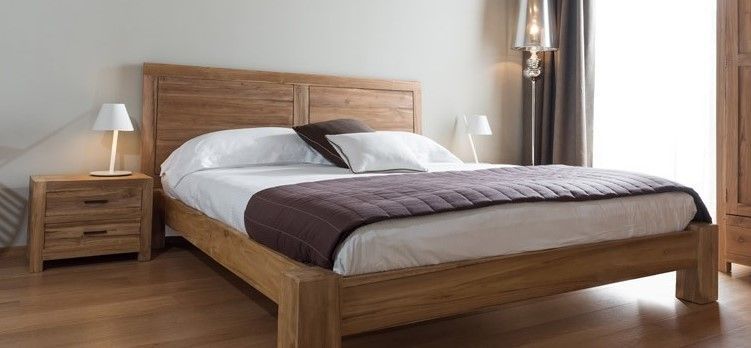 Una camera da letto con un letto di legno, un comodino e una lampada.