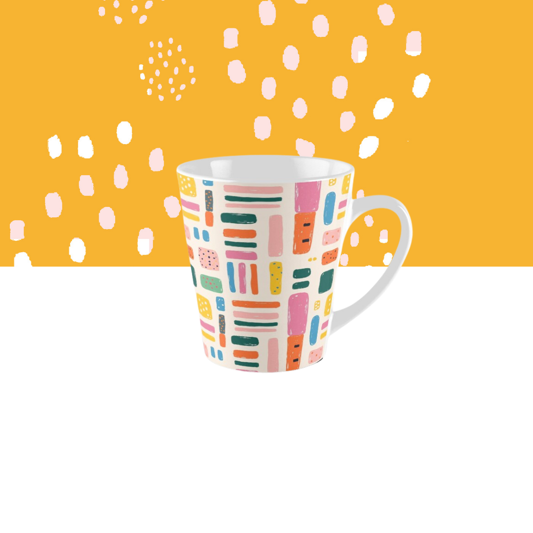 Colorful patterned mug on white surface against orange background with scattered white dots