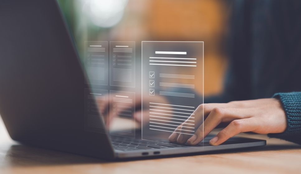 A person typing on a laptop with a translucent, glowing digital document hovering above the keyboard.