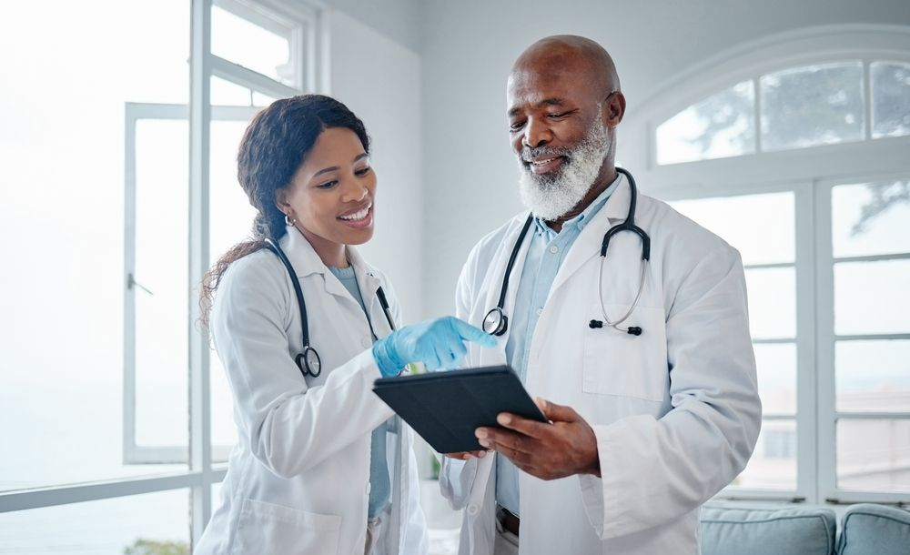 A person works on a laptop at a desk with digital overlays of mail and business report icons floating above the keyboard.