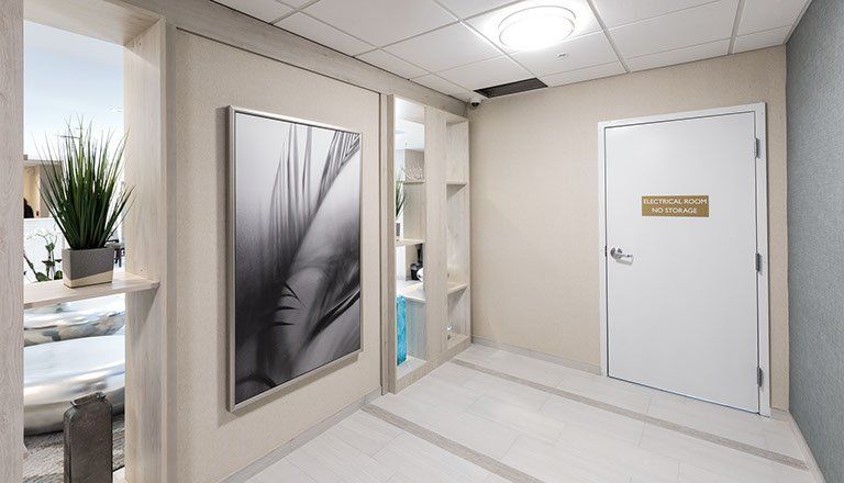 Hallway with a painting, white door, and built-in shelving. Light color scheme.