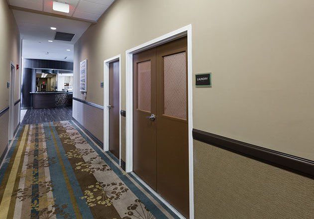Hotel hallway with doors and patterned carpet.
