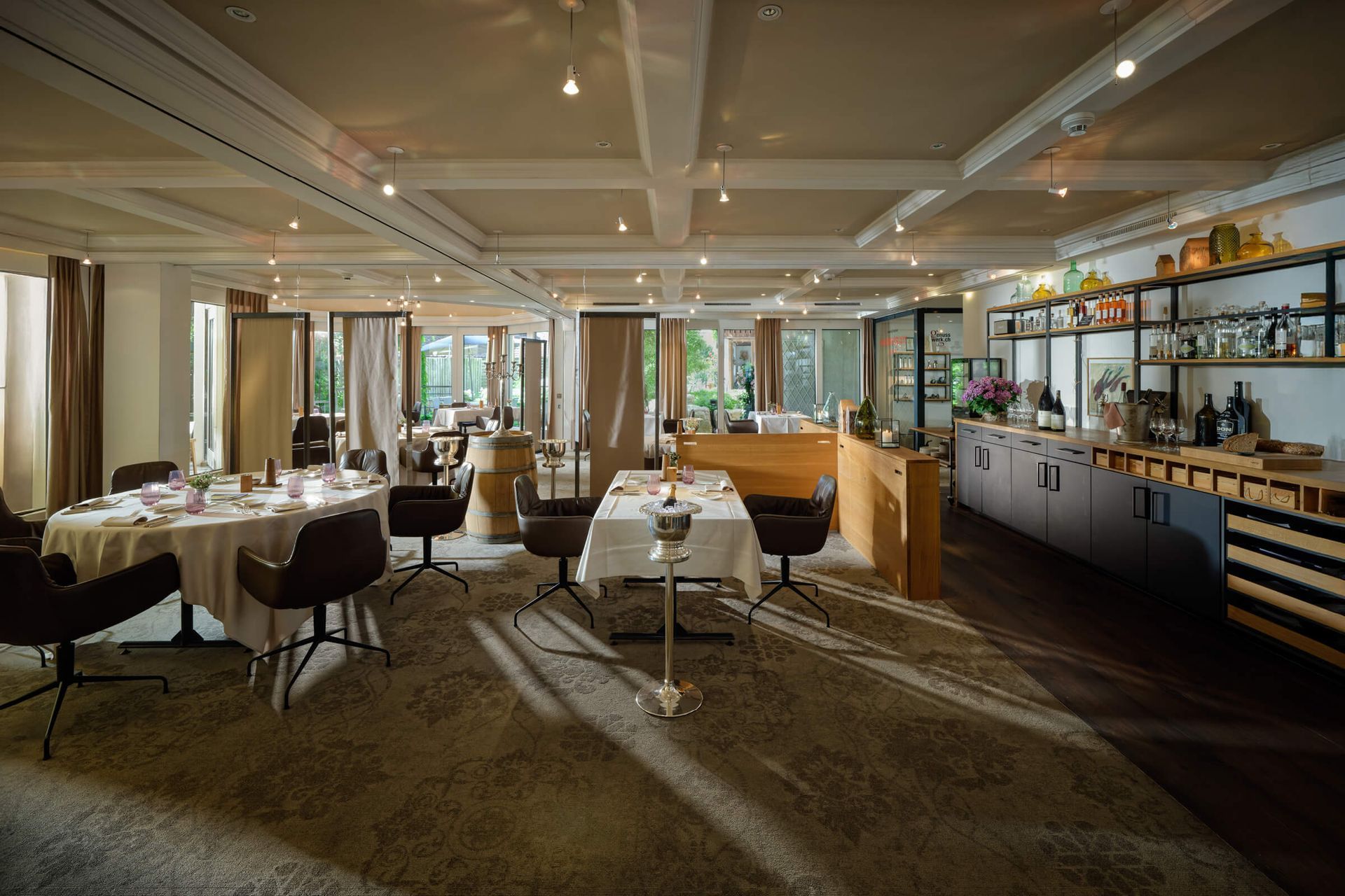 Elegantes Restaurant mit gedeckten Tischen, warmem Licht und einer Bar an der rechten Wand