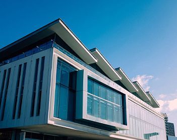 A large building with a lot of windows and a blue sky in the background.