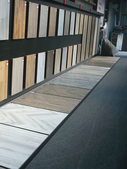 A row of wooden boards are lined up on a wall in a store.