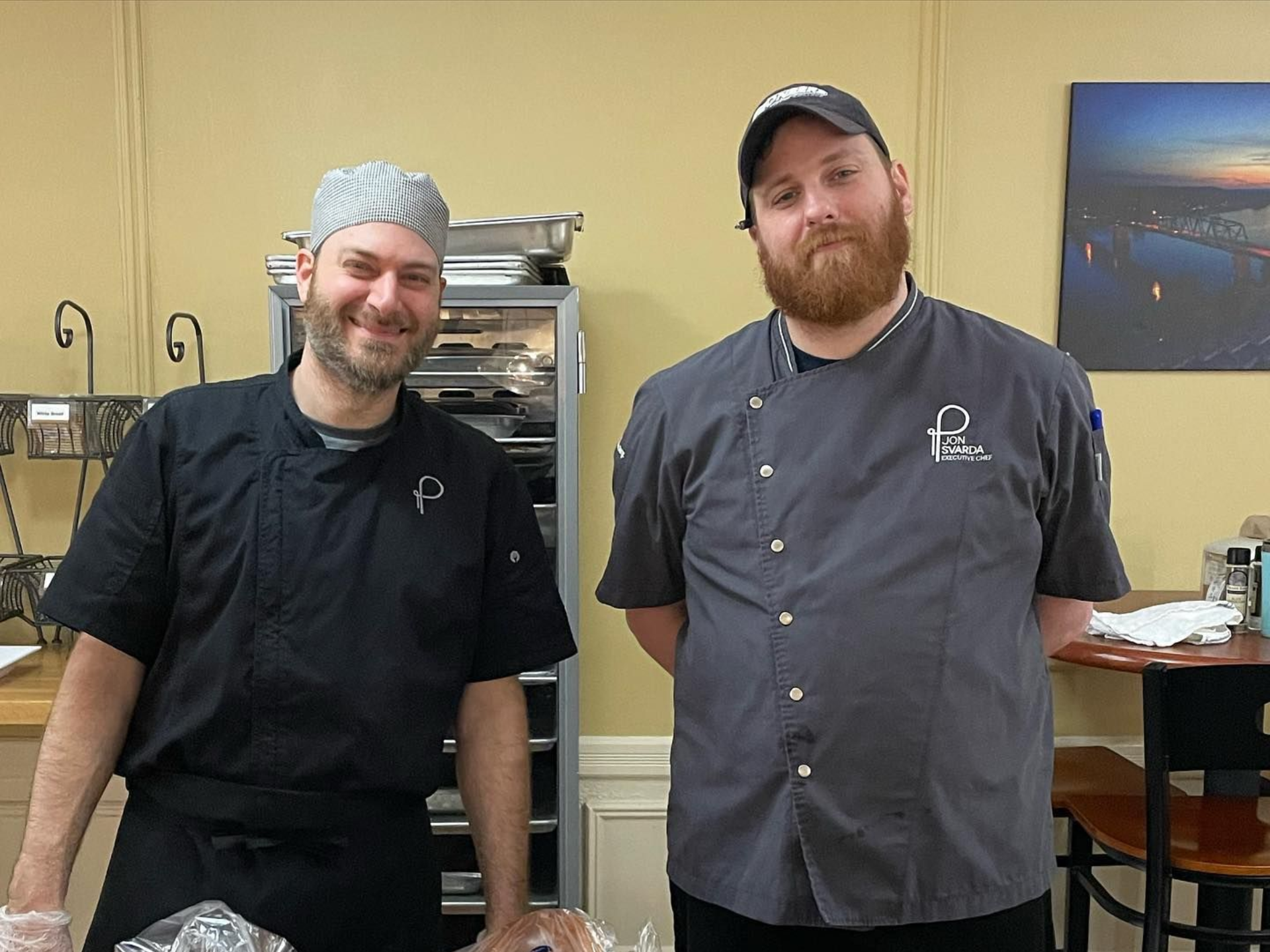 A man in a chef 's hat is posing for a picture with two other chefs