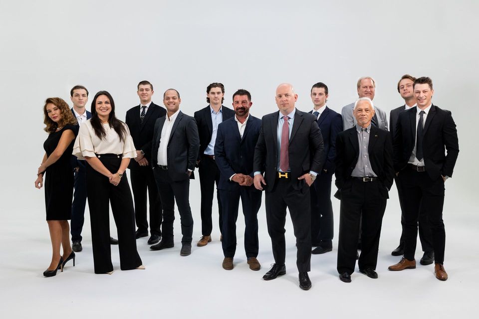 A group of people in suits and ties are posing for a picture.