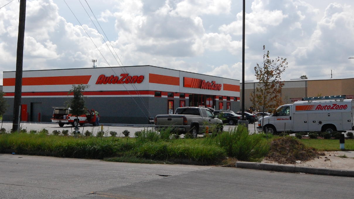 A white truck is parked in front of an autozone