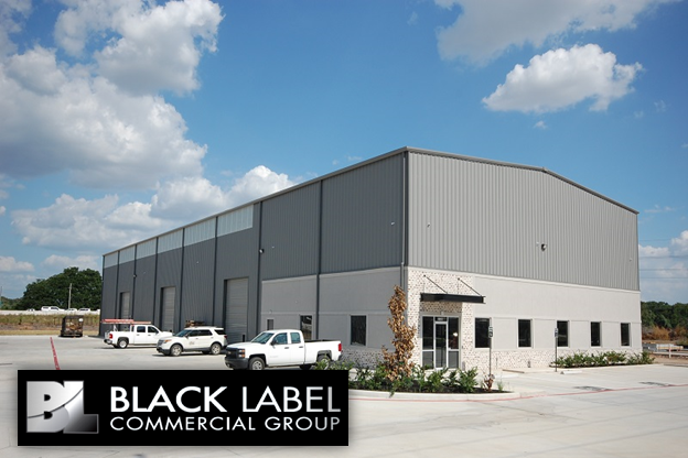 A black label commercial group building with trucks parked in front of it