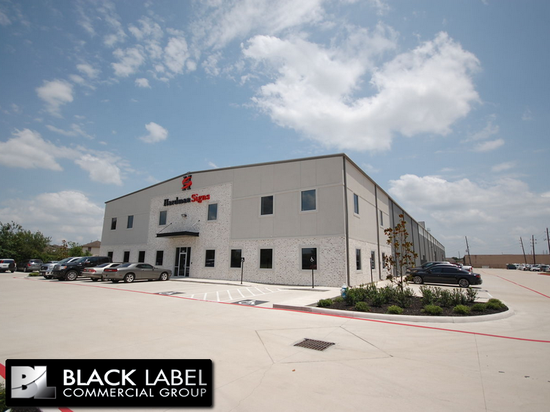 A black label commercial group building with cars parked in front of it