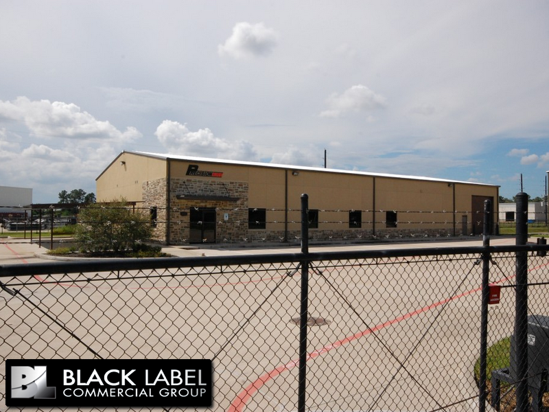A black label commercial group building is behind a chain link fence