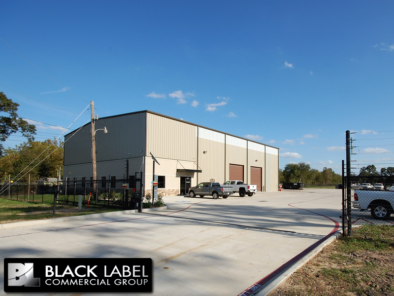 A black label commercial group building with trucks parked in front of it