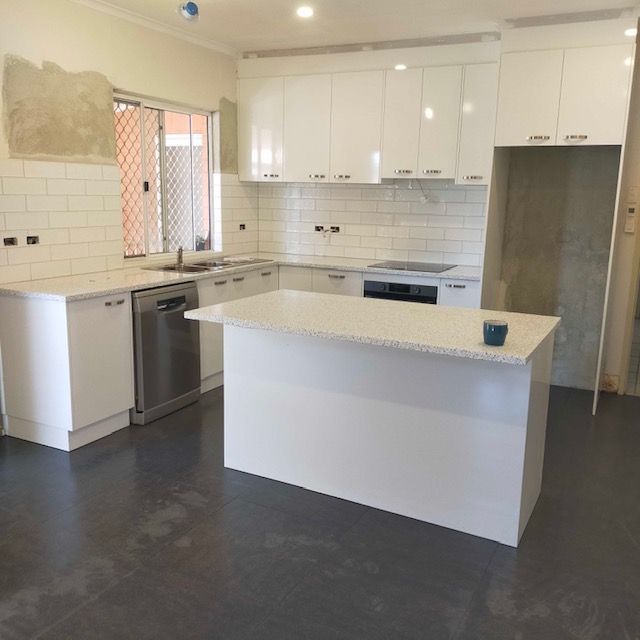 A kitchen with white cabinets and a large island