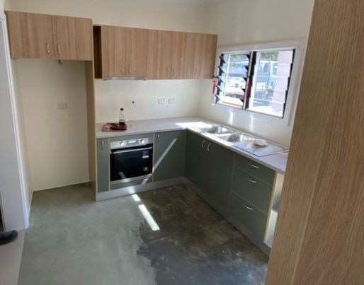 A kitchen with wooden cabinets and a stove top oven