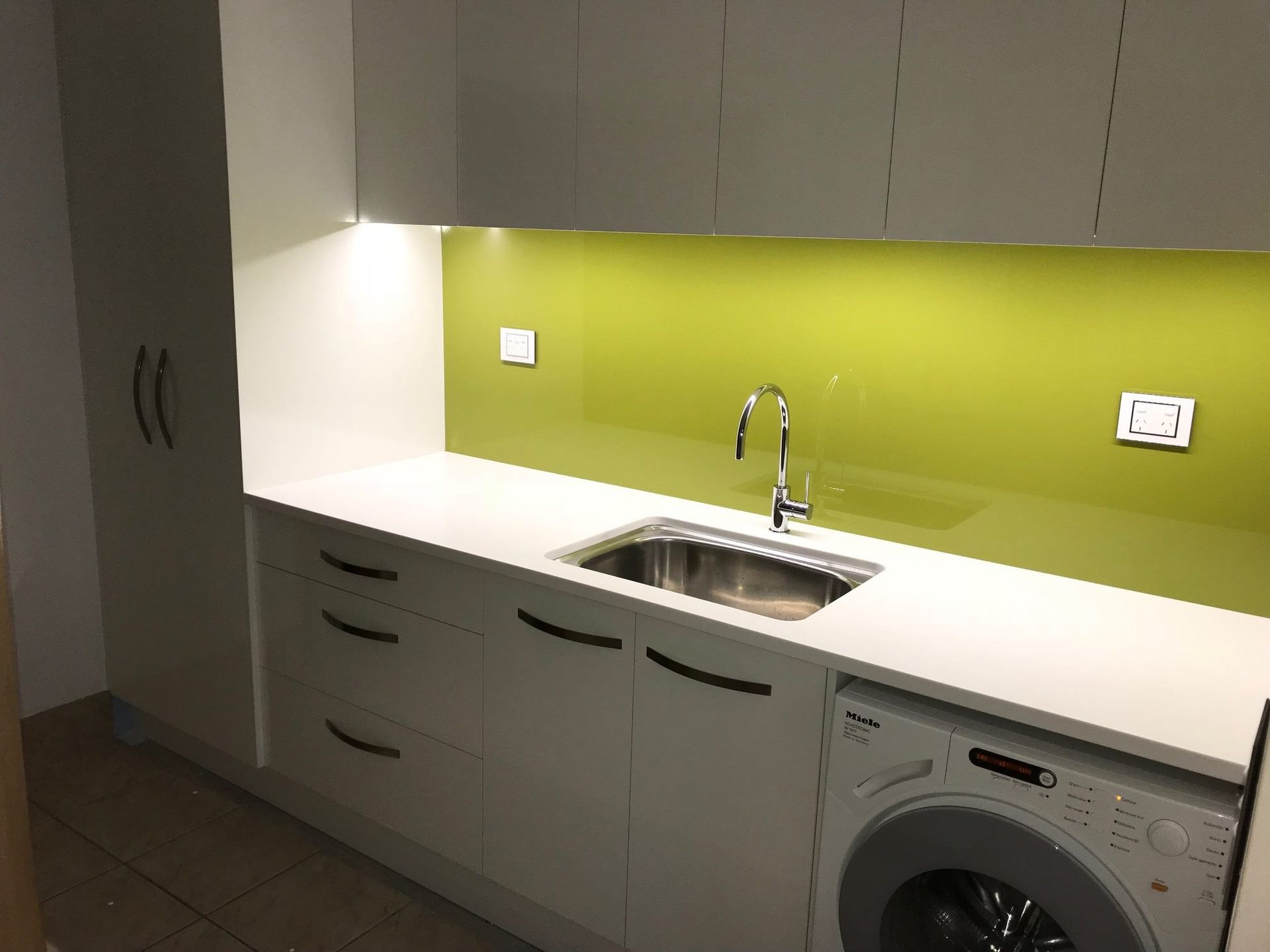A kitchen with a sink , washer and dryer.