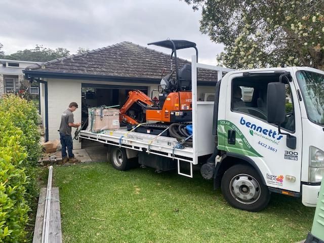 A Man is standing next to a truck in front of a house — Bennett's Servicing and Plumbing In South Nowra, NSW